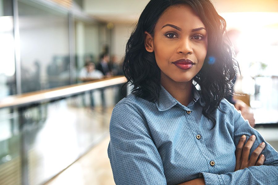 Home - African American Business Woman with Arms Crossed and Slightly Smiling